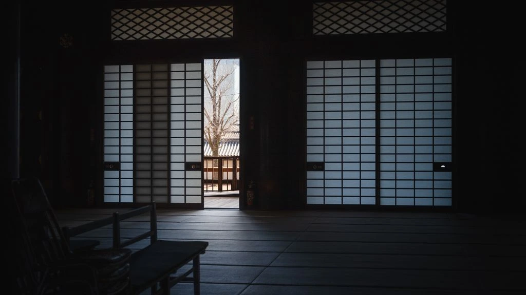 A native Japanese instructor coaching an adult learner in a warm Kyoto machiya classroom.